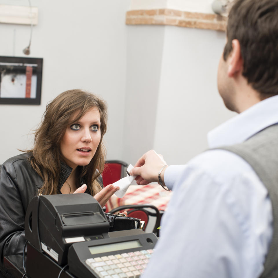 person holding a receipt looking upset