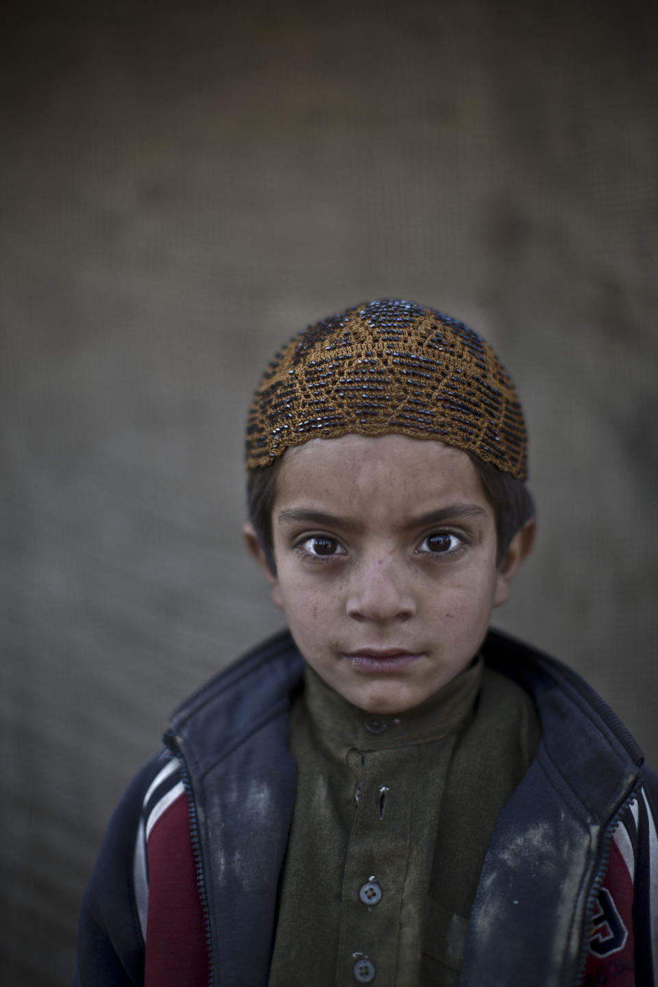 In this Monday, Jan. 27, 2014 photo, Afghan refugee boy, Allam Ahmad, 6, poses for a picture, while playing with other children in a slum on the outskirts of Islamabad, Pakistan. For more than three decades, Pakistan has been home to one of the world’s largest refugee communities: hundreds of thousands of Afghans who have fled the repeated wars and fighting their country has undergone. Since the 2002 U.S.-led invasion of Afghanistan, some 3.8 million Afghans have returned to their home country, according to the U.N.’s refugee agency. (AP Photo/Muhammed Muheisen)