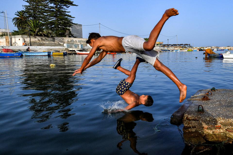 Children dive to into the Khaireddine Canal in the suburbs of Tunis on July 17, 2023.