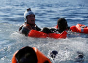 A rescue swimmer holds onto migrants frantically trying to stay afloat after falling off their rubber dinghy during a rescue operation by the Malta-based NGO Migrant Offshore Aid Station (MOAS) ship in the central Mediterranean in international waters some 15 nautical miles off the coast of Zawiya in Libya, April 14, 2017. REUTERS/Darrin Zammit Lupi