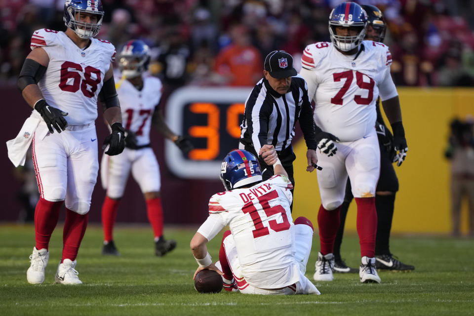 New York Giants quarterback Tommy DeVito (15) is helped by NFL umpire Duane Heydt after getting sacked during the second half of an NFL football game against the Washington Commanders, Sunday, Nov. 19, 2023, in Landover, Md. (AP Photo/Andrew Harnik)