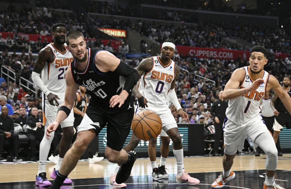 Clippers center Ivica Zubac beats Phoenix Suns guard Devin Booker to a loose ball.