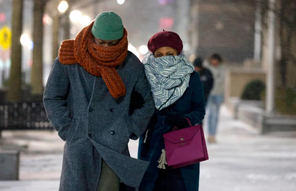 Yasmin Johnson and her boyfriend Nelson Jenkins walk down Fayetteville Street in downtown Raleigh during the evening snow Friday, Jan. 21, 2022.