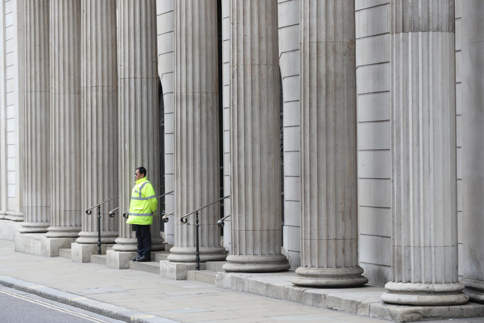 A lone security guard stands outside the Bank of England, in the City of London, as the UK's coronavirus death toll reached 144 as of 1pm on Thursday, with around four in 10 of all deaths so far in London.