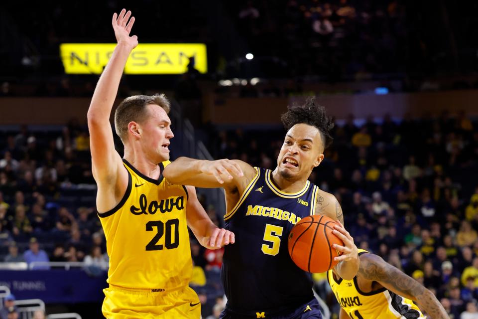 Michigan Wolverines forward Terrance Williams II (5) dribbles defended by Iowa Hawkeyes forward Payton Sandfort (20) in the first half at Crisler Center in Ann Arbor on Saturday, Jan. 27, 2024.