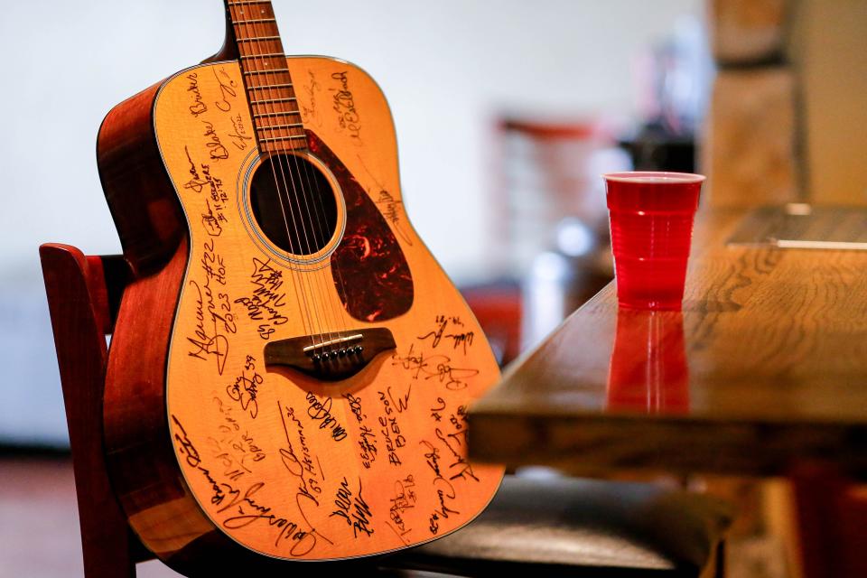 A red solo cup and a guitar played by Toby Keith are displayed on Feb. 7 where Keith would regularly sit at Othello's Italian Restaurant in Norman.