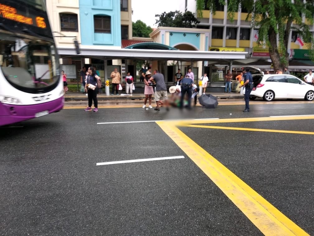 Policemen and passers-by attending to the victim after the assault. (Photo: Facebook page of KP Lau)