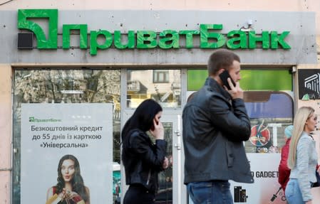 FILE PHOTO: People walk past a branch of PrivatBank, the country's biggest lender, in Kiev