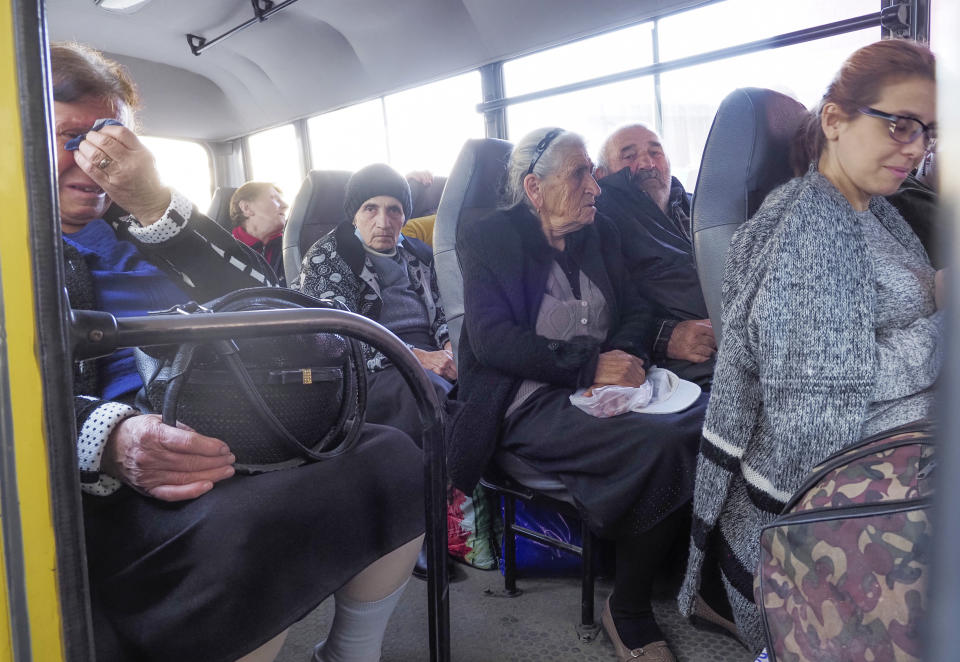 People sit in a bus as they prepare to leave Stepanakert, the separatist region of Nagorno-Karabakh, Friday, Oct. 30, 2020. The Azerbaijani army has closed in on a key town in the separatist territory of Nagorno-Karabakh following more than a month of intense fighting. (AP Photo)