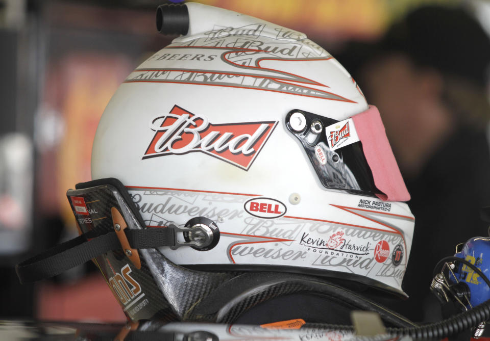 FILE - In this Feb. 16, 2011, file photo, NASCAR driver Kevin Harvick's HANS device equipped helmet rests on the roof of his race car before practice for the Daytona 500 auto race at Daytona International Speedway in Daytona Beach, Fla. The lightweight head restraint co-invented by veteran sports car racer Jim Downing keeps a driver's head from snapping forward violently in a crash and has been credited with saving numerous lives in its two decades of use. (AP Photo/Terry Renna, File)