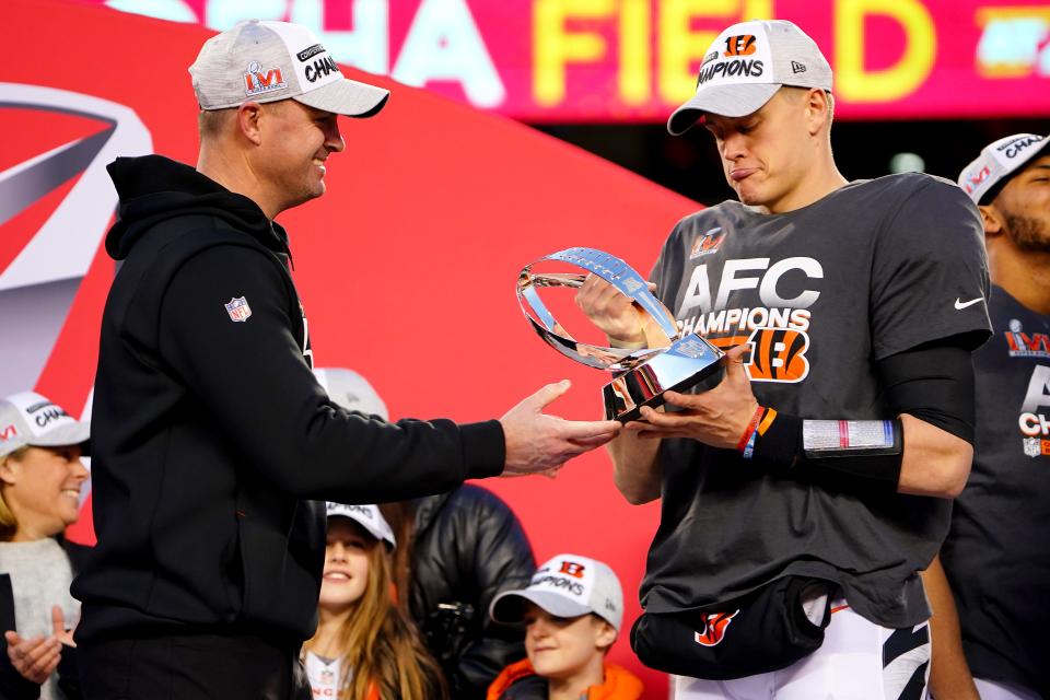 Cincinnati Bengals head coach Zac Taylor hands Cincinnati Bengals quarterback Joe Burrow (9) the AFC Championship trophy at the conclusion of the AFC championship NFL football game, Sunday, Jan. 30, 2022, at GEHA Field at Arrowhead Stadium in Kansas City, Mo. The Cincinnati Bengals defeated the Kansas City Chiefs, 27-24, to advance to the Super Bowl. 