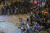 Police form up against journalists and protesters gathered in Wong Tai Sin district in Hong Kong on Saturday, Aug. 3, 2019. Protesters and authorities clashed in Hong Kong again on Saturday, as demonstrators removed a Chinese national flag from its pole and flung it into the city's iconic Victoria Harbour and police fired tear gas after some protesters vandalized a police station. (AP Photo/Kin Cheung)