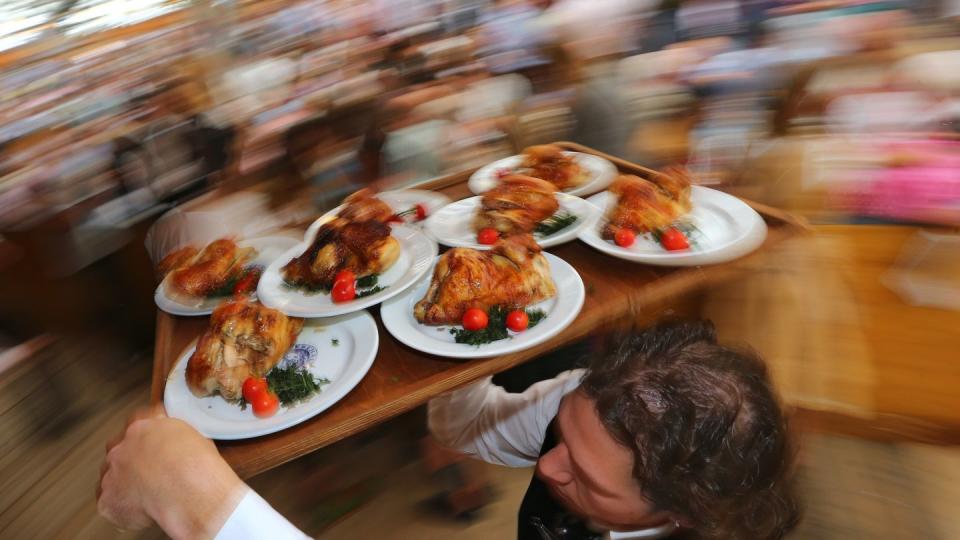 Diät geht anders: Kellner auf dem Oktoberfest mit einem Tablett Hendl (Hähnchen). Foto: Karl-Josef Hildenbrand