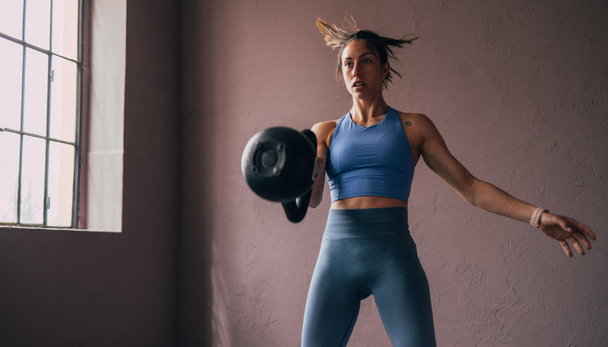  Woman exercises with kettlebell. 