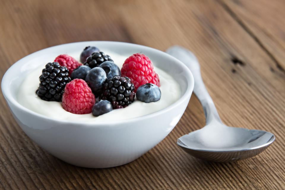 Bowl of fresh mixed berries and yogurt with farm fresh strawberries, blackberries and blueberries