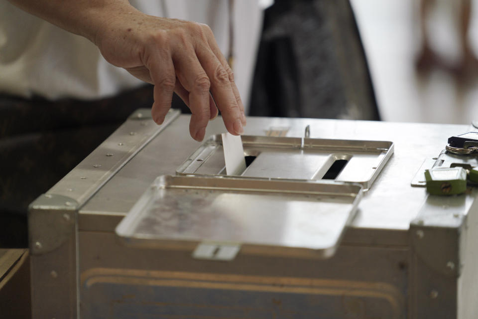 A voter casts a ballot in the Tokyo gubernatorial election at a polling station Sunday, July 5, 2020, in Tokyo. Gov. Yuriko Koike is poised to be reelected in Sunday’s polls, buoyed by public support for her coronavirus handling despite a recent rise in infections that has raised concerns of a resurgence of the disease. (AP Photo/Eugene Hoshiko)