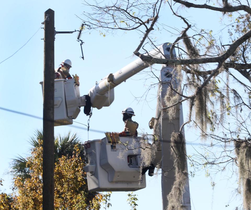 Power company crews work on Fulton Street in Daytona Beach's Midtown neighborhood on Sunday, as the area continues to recover from Tropical Storm Ian.