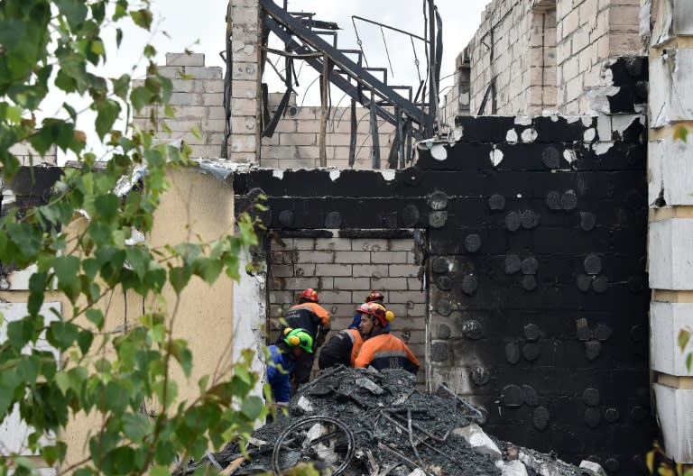Ukrainian fire-fighters investigate the site of a blaze in the village of Litochky, on May 29, 2016