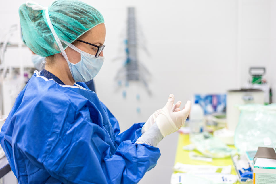 Covid-19. Female nurse puts on protective gloves. Personal protective equipment in the fight against Coronavirus disease.