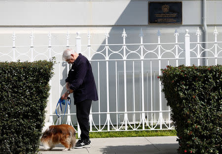 A man walks his dog outside the gate to the entrance of the Consulate General of Russia in San Francisco, California, U.S., August 31, 2017. REUTERS/Stephen Lam