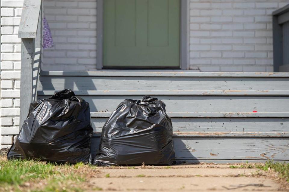 Taylynne Ivie leaves two trash bags out on the front porch of her home on Tuesday, April 4, 2023, in Kansas City. Ivie is one of the many residents across the metro who have experienced challenges with the city’s two bag trash limit.