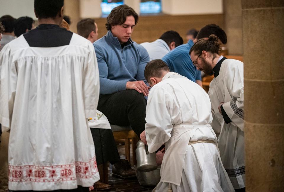 Charles Wesley, 21, of Clinton Township, is preparing to participate in the Order of Christian Initiation for Adults to be a fully realized member of the Catholic faith. As part of this process, Wesley has his feet washed during Holy Thursday services by the Rev. Matthew Hood on Thursday, April 6, 2023 at Our Lady of the Rosary Catholic Church in Detroit.