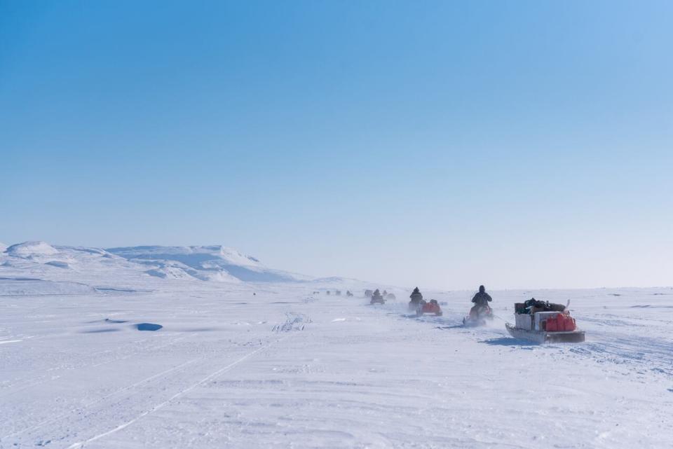 A convoy of support snowmobiles with qamutiks in tow, head toward the first Nunavut Quest camp, roughly 50km outside of Arctic Bay, Nunavut, Monday, April 18, 2022. 