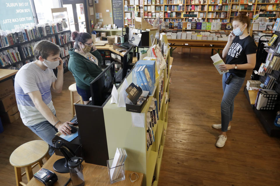 En esta fotografía del 25 de junio de 2020 empleados ayudan a clientes con sus órdenes por teléfono en la librería Parnassus Books en Nashville, Tennessee. La librería copropiedad de la novelista Ann Patchett abrió en 2011 en un ambiente adverso y logró duplicar su tamaño, la pandemia de coronavirus tampoco la ha cerrado. (Foto AP/Mark Humphrey)