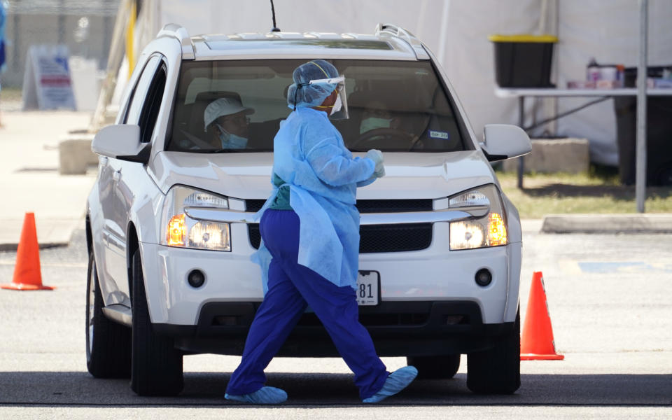 Medical personnel administer COVID-19 testing at a drive-thru site, Friday, Aug. 14, 2020, in San Antonio. Coronavirus testing in Texas has dropped significantly, mirroring nationwide trends, just as schools reopen and football teams charge ahead with plans to play. (AP Photo/Eric Gay)