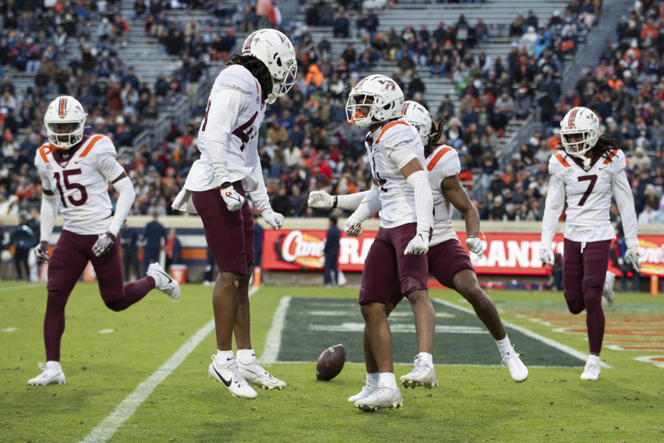 The Virginia Tech defense celebrates after intercepting a pass against Virginia during the first half of an NCAA college football game Saturday, Nov. 25, 2023, in Charlottesville, Va. (AP Photo/Mike Caudill)