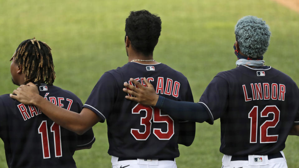 Members of the Cleveland Indians stand for the National Anthem before a preseason baseball game against the Pittsburgh Pirates, Monday, July 20, 2020, in Cleveland. (AP Photo/Tony Dejak)