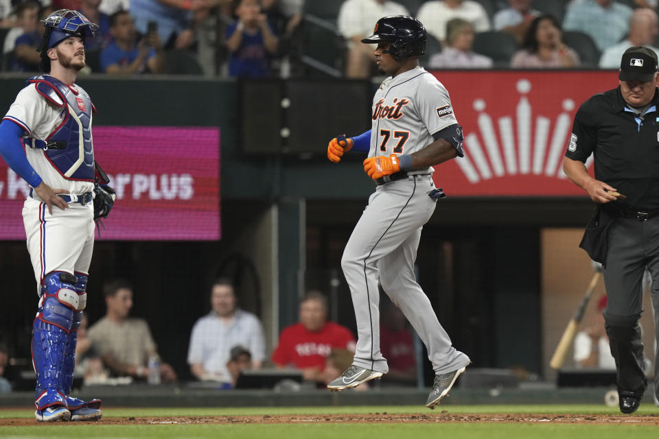 Detroit Tigers' Andy Ibanez (77) crosses home plate to score in front of Texas Rangers catcher Jonah Heim, left, during the third inning of a baseball game in Arlington, Texas, Monday, June 26, 2023. (AP Photo/LM Otero)