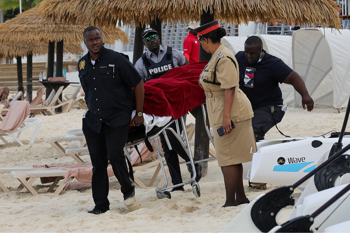 Mortuary services personnel transport the body of the female tourist after shark attack (REUTERS)