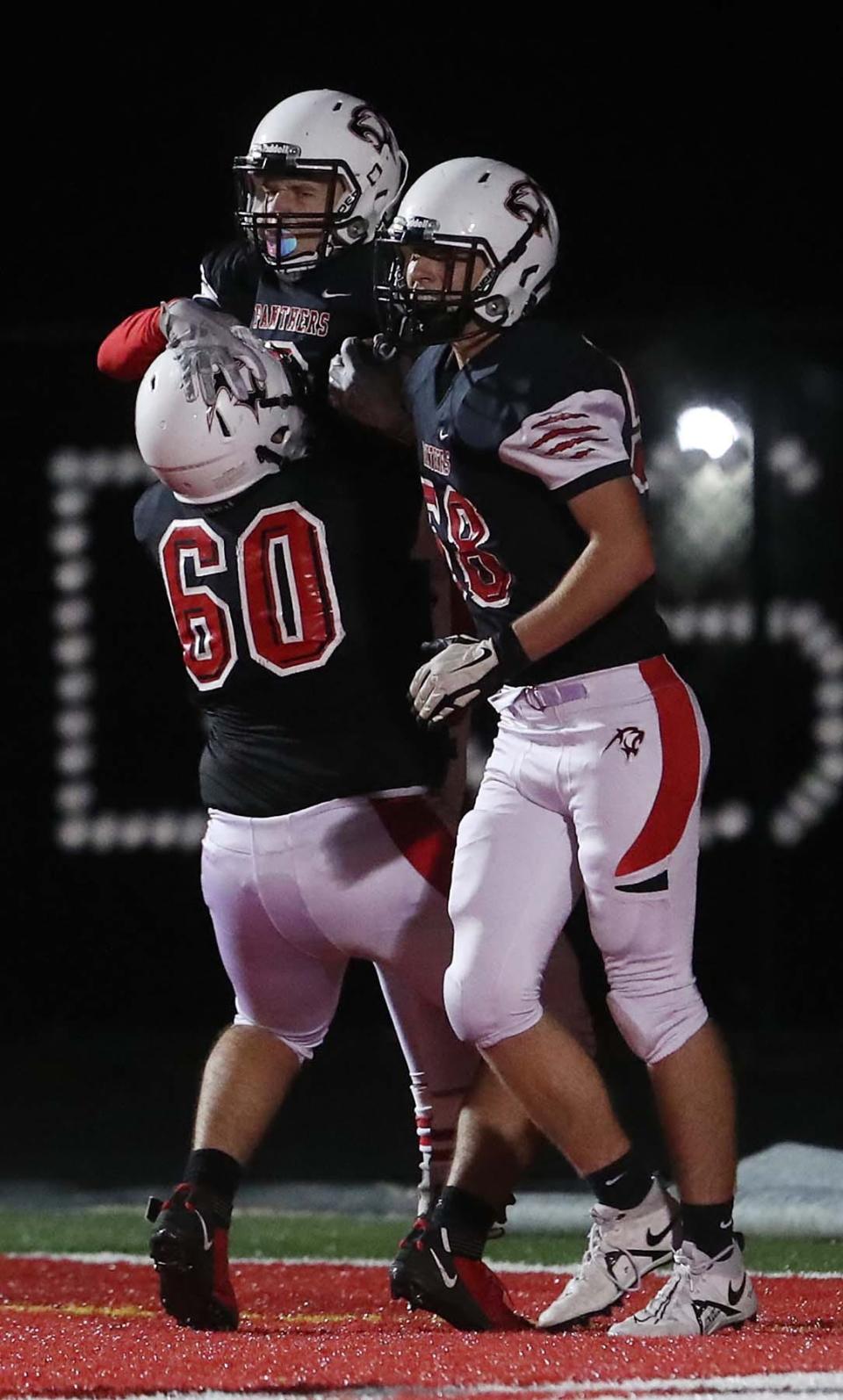 Norton running back Noah Willig, center, celebrates his touchdown with teammates Daniel Hopkins, left, and Alex Swinehart during the first quarter of their game against Field at Norton High School Friday in Norton.