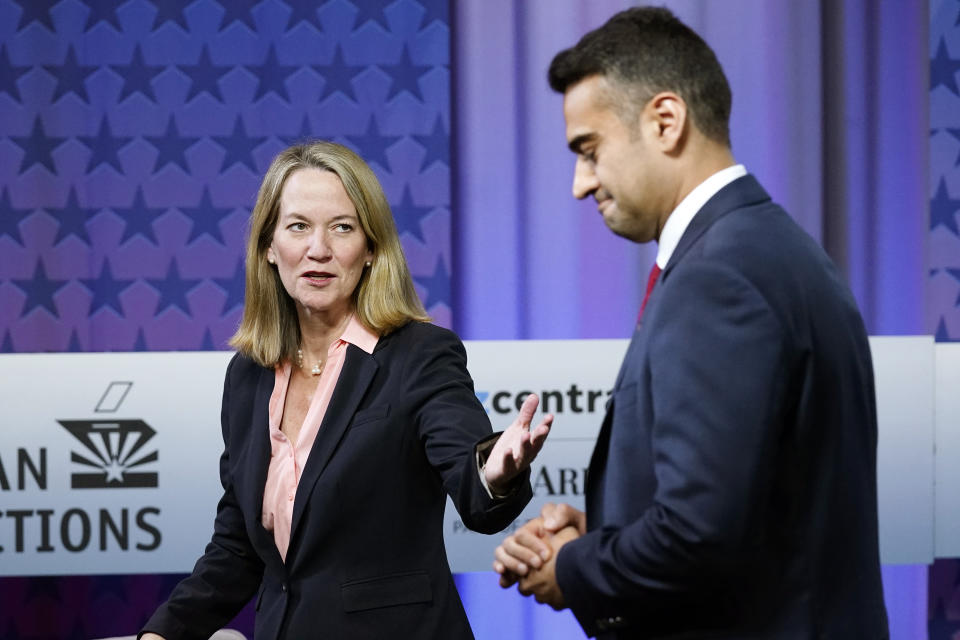 Arizona Attorney General candidates, Democrat Kris Mayes, left, talks with Republican Abraham Hamadeh, right, prior to a televised debate, Wednesday, Sept. 28, 2022. (AP Photo/Ross D. Franklin)