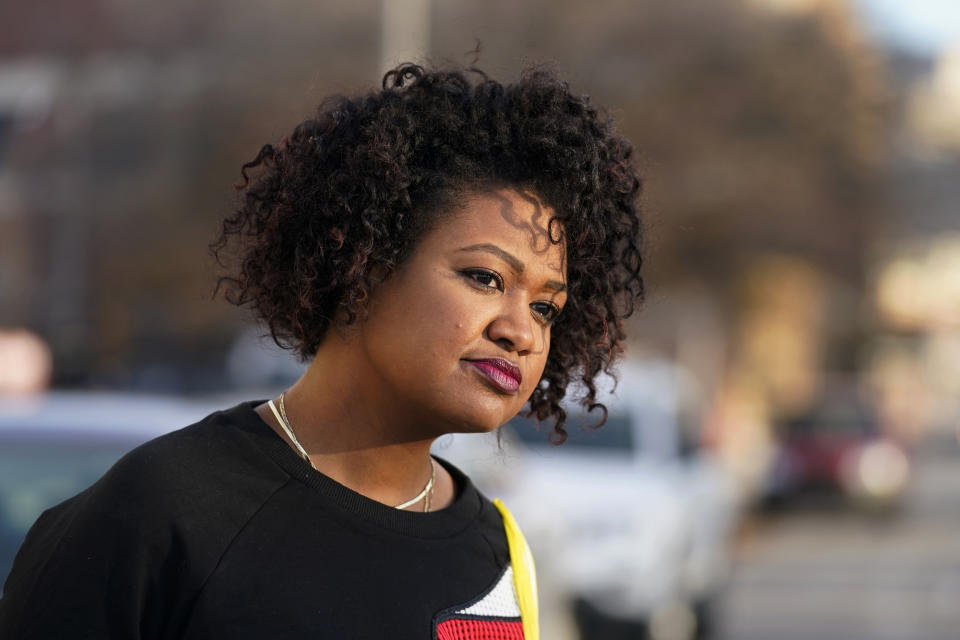 Malina Jeffers looks at the Black Lives Matter street mural stretching across Indiana Avenue, Thursday, Dec. 10, 2020, in Indianapolis. The mural is wearing down from traffic, and with winter will come weather damage and snow plows. (AP Photo/Darron Cummings)