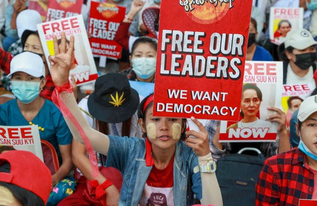 Anti-coup protesters display images of deposed Myanmar leader Aung San Suu Kyi in Yangon, Myanmar 