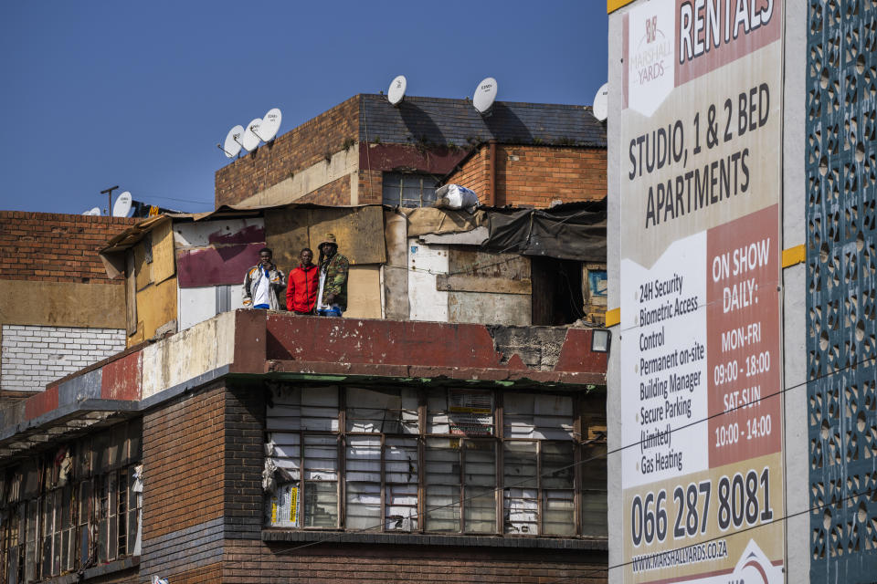 Squaters stand in front of their shacks on the rooftop of a building in Johannesburg, South Africa, Friday, Sept. 1, 2023. Johannesburg has established itself as one of the best cities in the world, South Africa's economic hub where careers are made and dreams come true. But over the last few years, that image and reputation has been changing. (AP Photo/Jerome Delay)