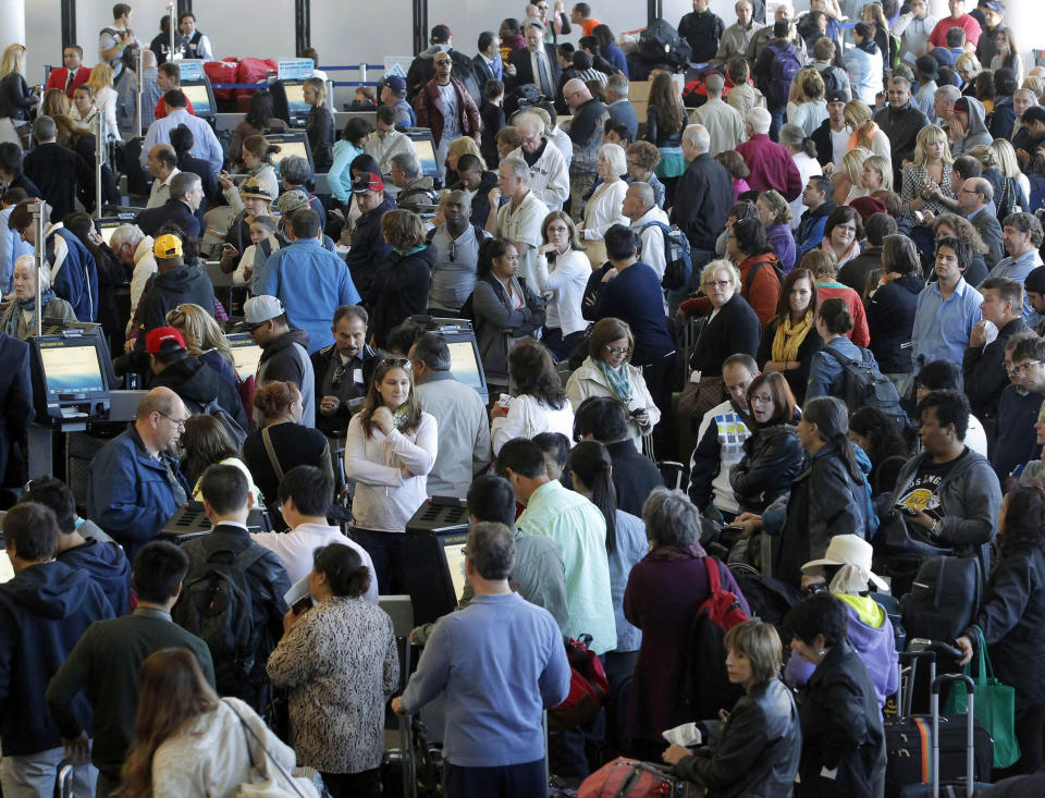 Passengers gather at the American Airlines check-in for flights at Los Angeles International Airport on Tuesday, April 16, 2013. Computer problems forced American Airlines to ground flights across the country Tuesday after the airline was unable to check passengers in and book passengers. (AP Photo/Nick Ut)