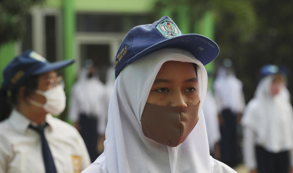Students wear face maska as a precaution against the new coronavirus during the first day of reopening of state high schools in Bekasi on the outskirts of Jakarta, Indonesia, July 13, 2020. (AP Photo/Achmad Ibrahim)