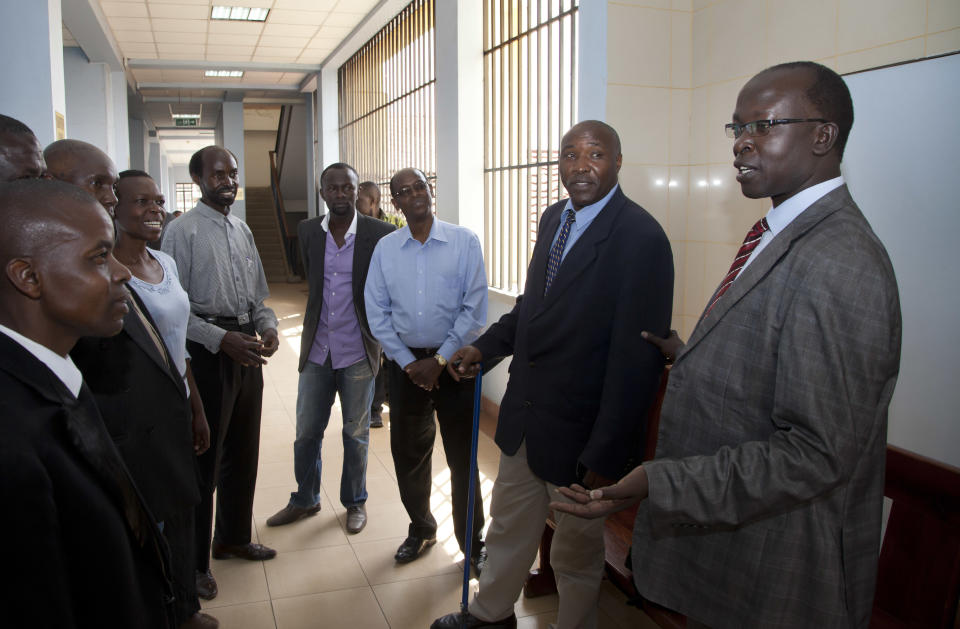 FILE - In this Friday, Oct. 18, 2013 file photo, Kenyan journalist Walter Barasa, right, speaks to supporters before attending a court hearing to determine whether authorities will enforce an International Criminal Court (ICC) arrest warrant against him, at the Milimani court in Nairobi, Kenya. A Kenyan court Friday, Jan. 31, 2014 refused to stop the arrest of Barasa who is wanted by the ICC for allegedly interfering with prosecution witnesses in the crimes against humanity case against Kenya's Deputy President William Ruto. (AP Photo/Sayyid Azim, File)