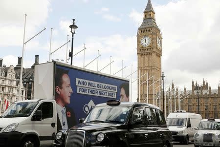 An advertising van with images of Britain's Prime Minister David Cameron and leader of the opposition Labour Party Ed Miliband drives around Parliament Square, central London, Britain, May 7, 2015. REUTERS/Phil Noble