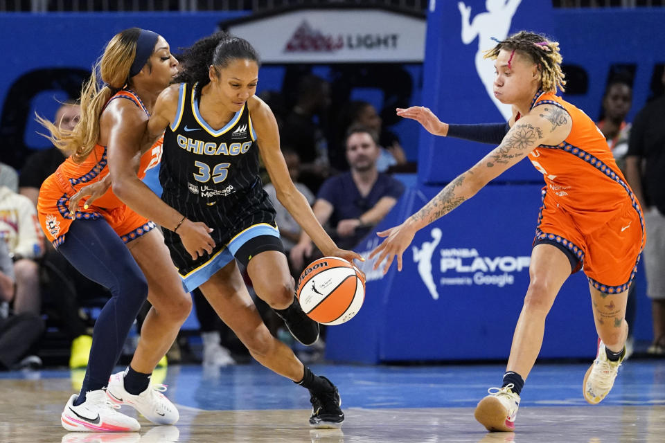 Chicago Sky guard Rebekah Gardner, center, drives as Connecticut Sun guard DiJonai Carrington, left, and guard Natisha Hiedeman defend during the second half of Game 2 in a WNBA basketball playoffs semifinal Wednesday, Aug. 31, 2022, in Chicago. The Sky won 85-77. (AP Photo/Nam Y. Huh)