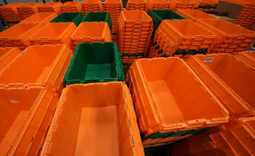 Orange and green plastic bins -- the company's signature colors -- zip along on conveyor belts overhead