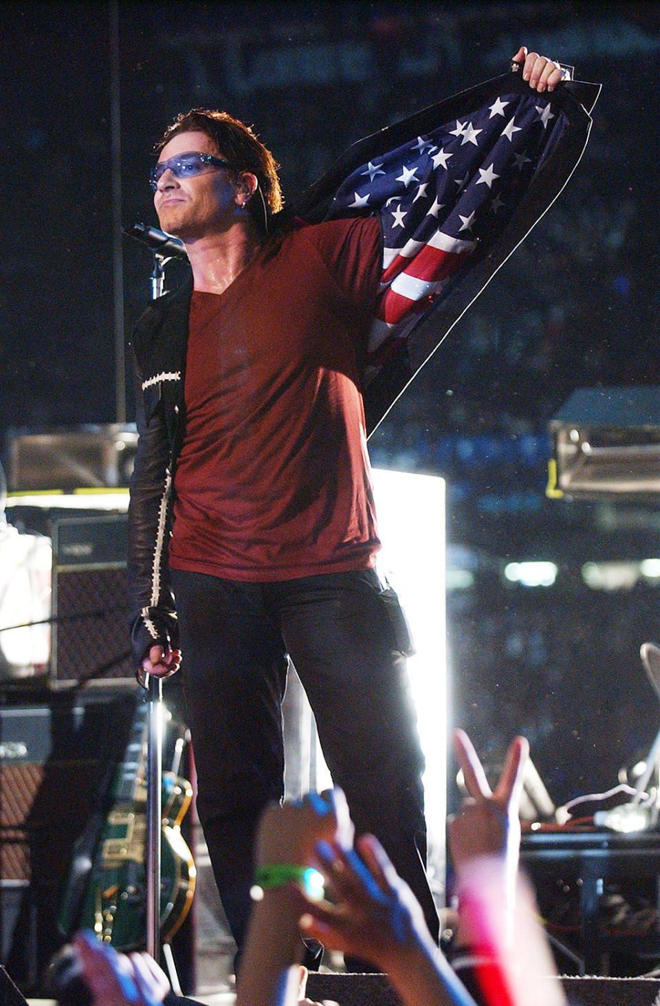 Bono, lead singer of U2, displays American flag lining in his jacket after singing “Where The Streets Have No Name”, during the halftime show of Super Bowl XXXVI in the Superdome, New Orleans, Louisiana, February 3, 2002.