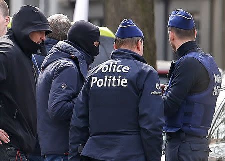 Belgian police secure the area nearby during a police search operation of an apartment complex in the central Brussels district of Etterbeek, April 9, 2016, which ended without any arrests made after the building's residents were evacuated. REUTERS/Yves Herman