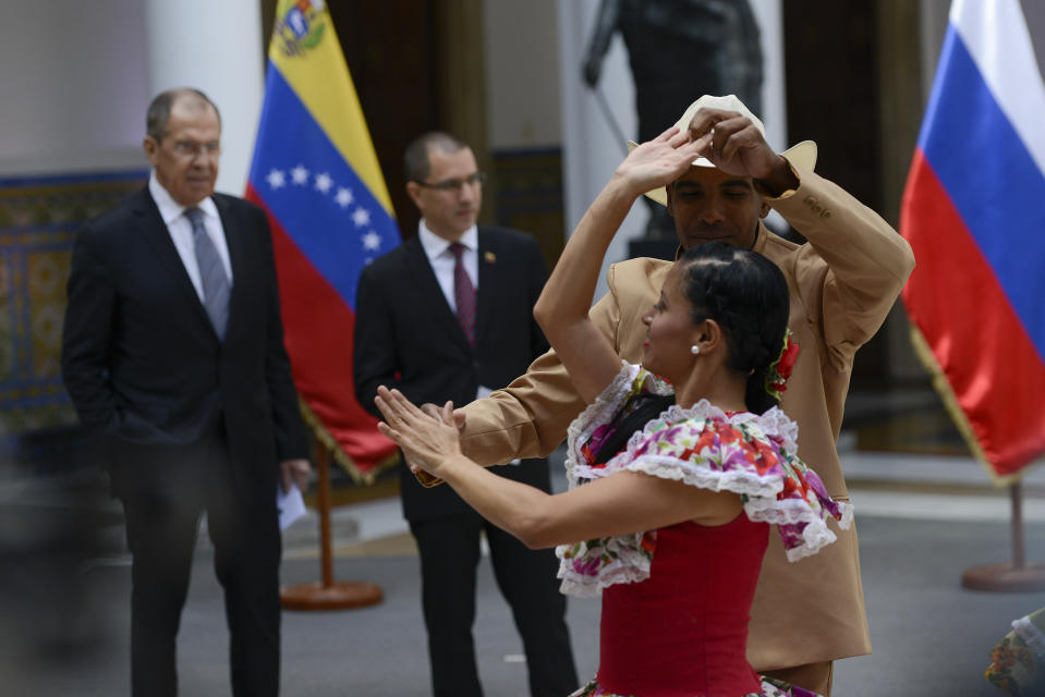 Russia's Foreign Minister Sergey Lavrov, left, and Venezuela's Foreign Minister Jorge Arreaza watch performers dance "Joropo" at the Foreign Ministry in Caracas, Venezuela, Friday, Feb. 7, 2020. (AP Photo/Matias Delacroix)