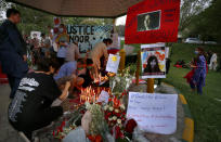 Women's rights activists place candles and flowers beside posters with the pictures of Noor Mukadam, who was recently beheaded, during a candle light vigil to pay tribute to Noor and other domestic violence victims in Islamabad, Pakistan, Sunday, July 25, 2021. The killing of Mukadam in an upscale neighborhood of Pakistan's capital has shone a spotlight on the relentless violence against women in the country. Rights activists say such gender-based assaults are on the rise as Pakistan barrels toward greater religious extremism. (AP Photo/Anjum Naveed)