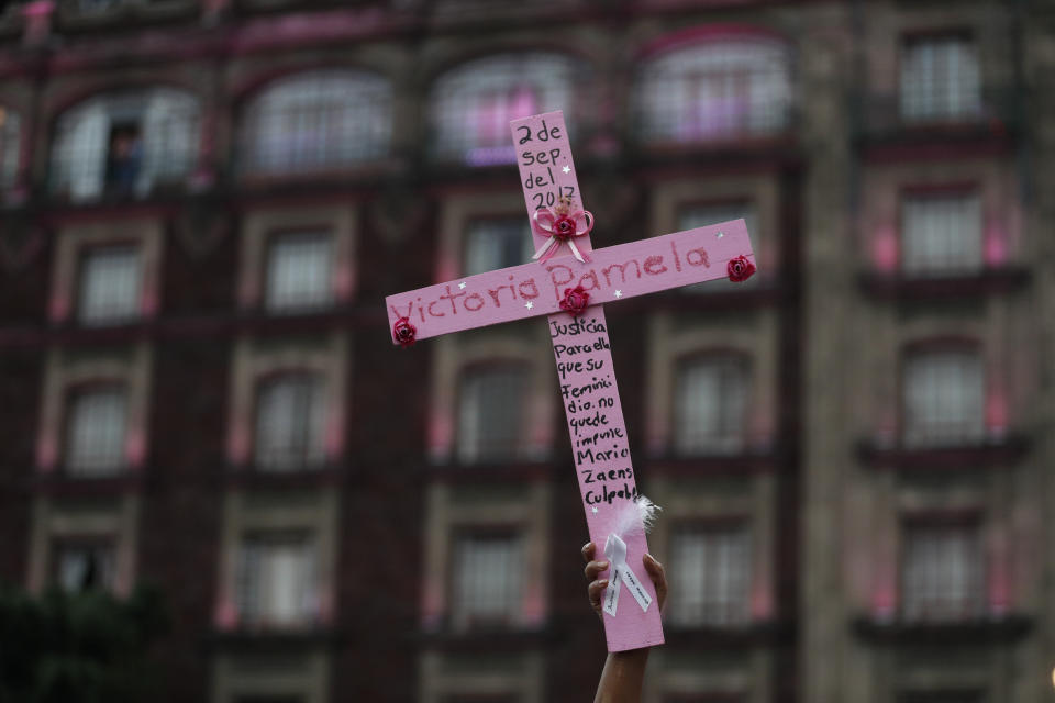 FILE - In this March 8, 2019 file photo, Consuelo Salas holds up a pink cross marked with the name of her daughter Vitoria Pamela Salas, who was killed in 2017 at age 23, as she calls for justice, in the Zocalo, Mexico City's main square, following a march. Hundreds plan to take to the streets of Mexico City again Sunday, Sept. 8, 2019, to demand justice for women who have been killed, kidnapped and sexually assaulted. (AP Photo/Rebecca Blackwell)