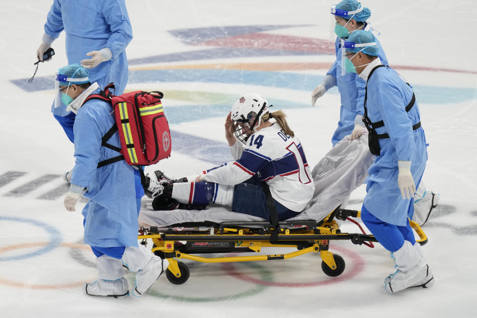 United States' Brianna Decker (14) is taken off the ice after being injured during a preliminary round women's hockey game against Finland at the 2022 Winter Olympics, Thursday, Feb. 3, 2022, in Beijing. (AP Photo/Petr David Josek)